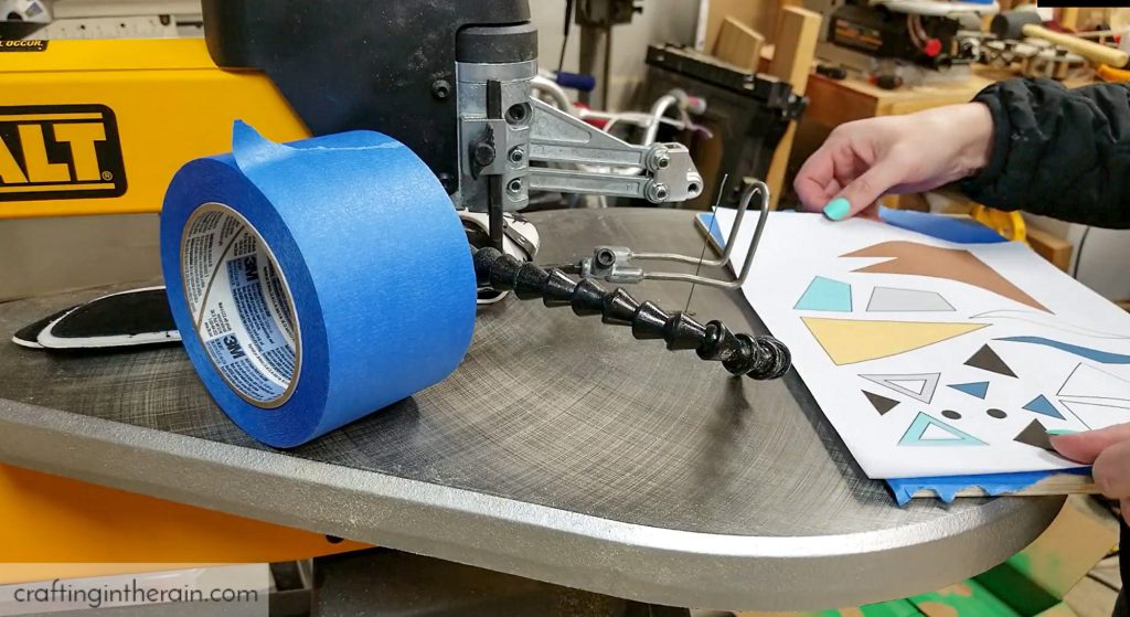 Apply scroll saw pattern to wood with painters tape